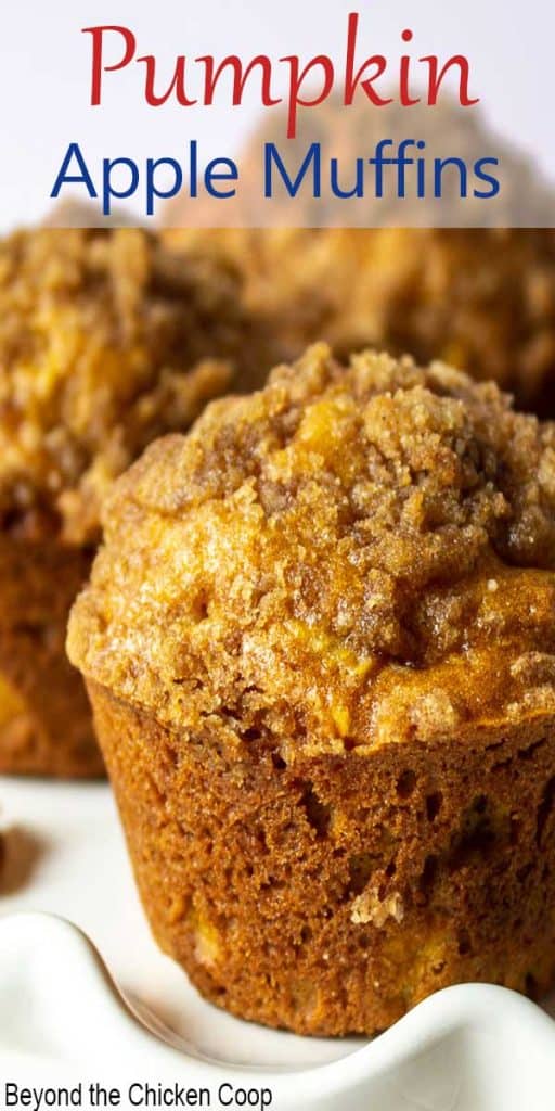 A pumpkin apple muffin on a white scalloped plate.