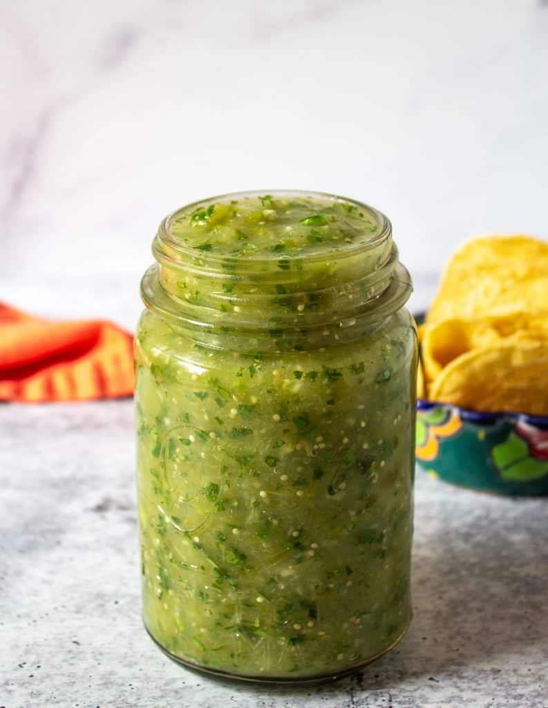 A glass jar filled with salsa verde.