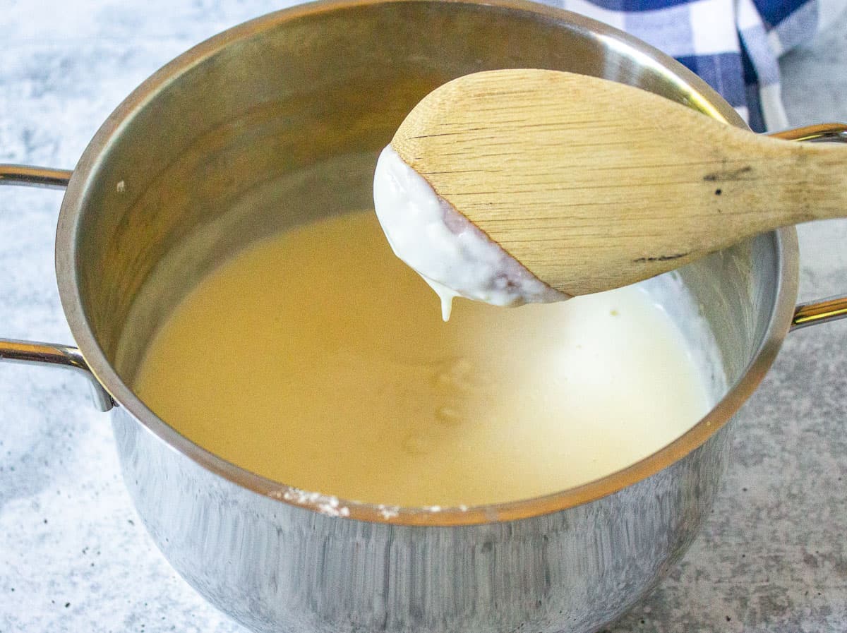 A roux in a sauce pan with a wooden spoon.