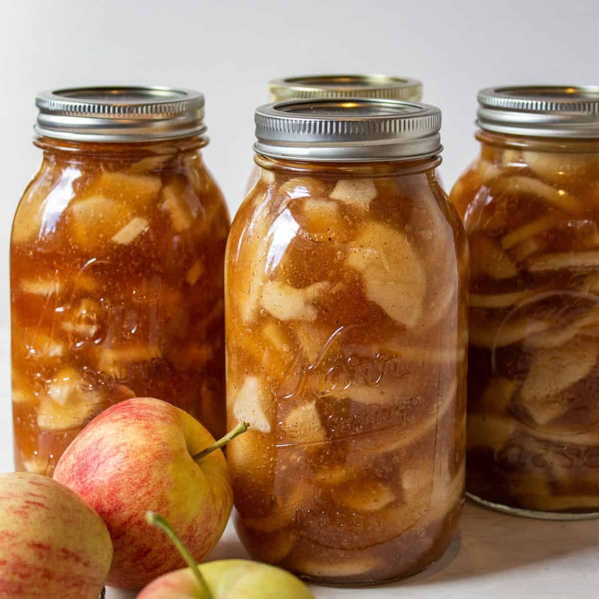 Quart sized canning jars filled with apple pie filling.