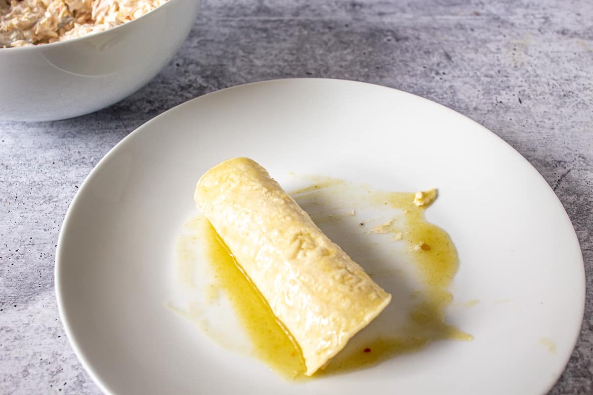 A rolled tortilla on a white plate.