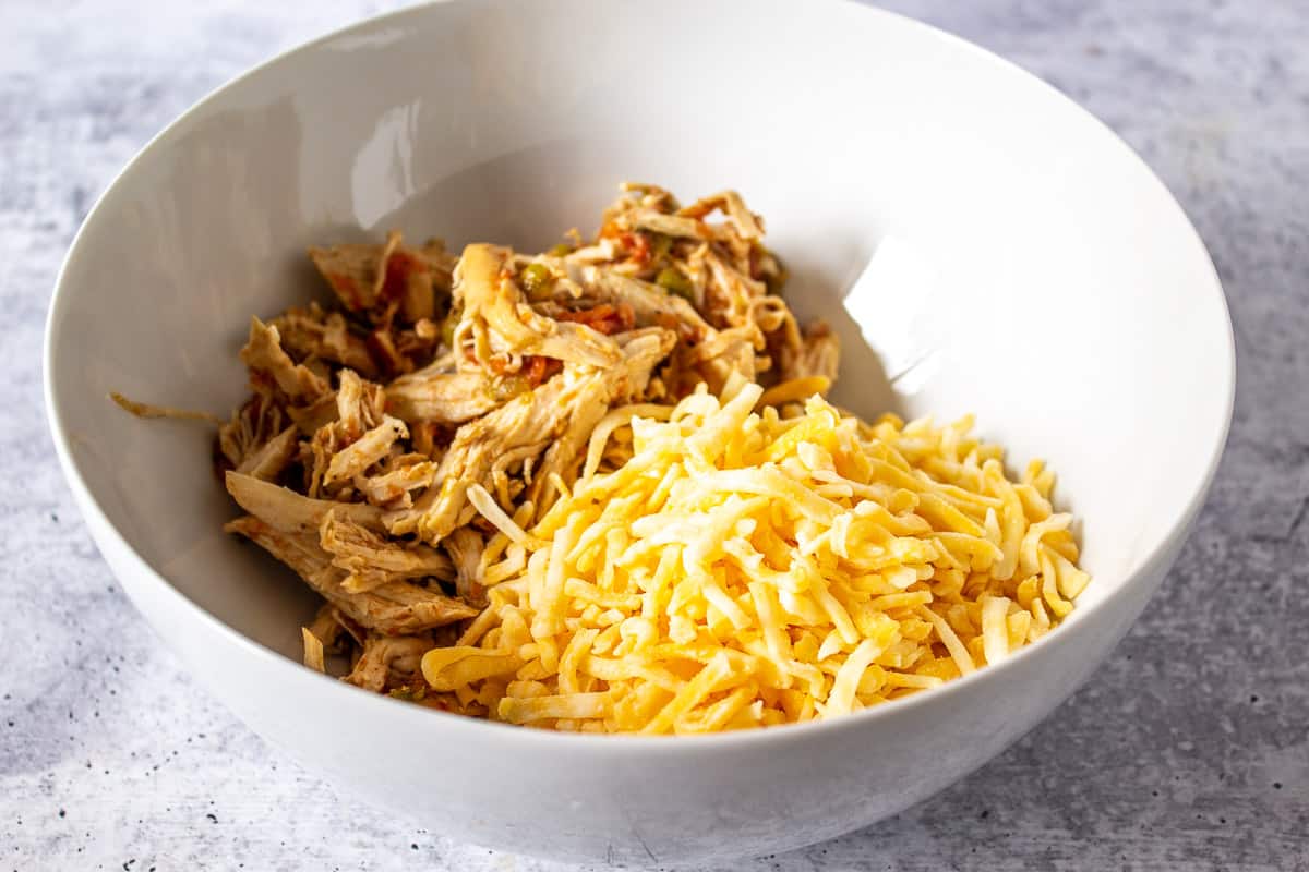 Shredded chicken and cheese in a bowl.