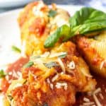 Stuffed pasta shells covered with marinara sauce and fresh herbs.