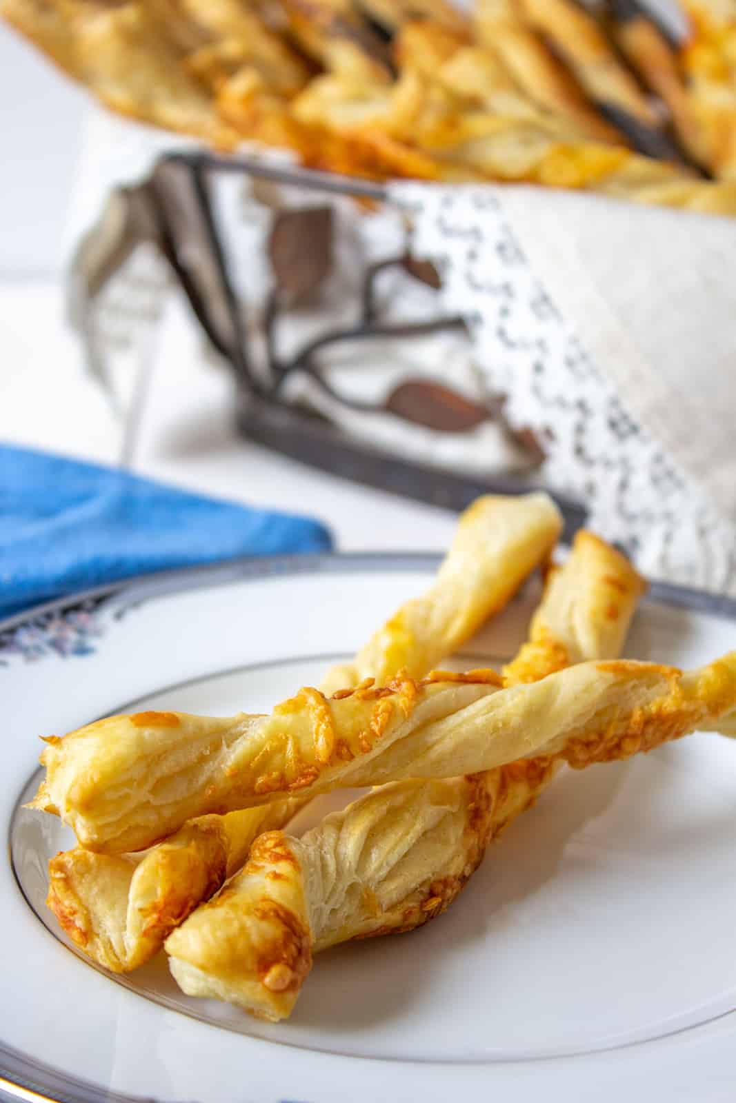 Three cheese straws on a small white plate.