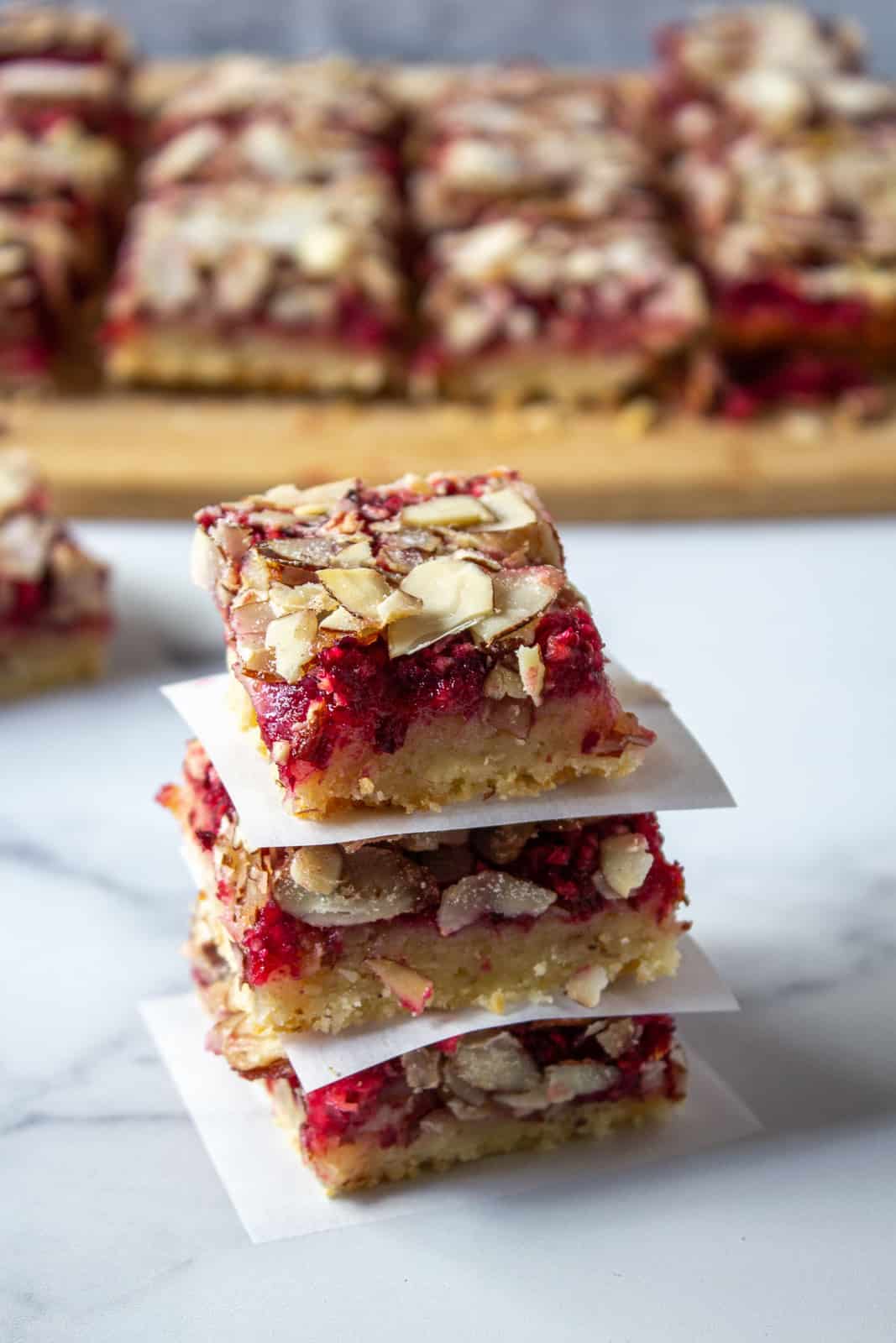 Three cranberry bars stacked on top of each other with a small piece of white paper between each bar.