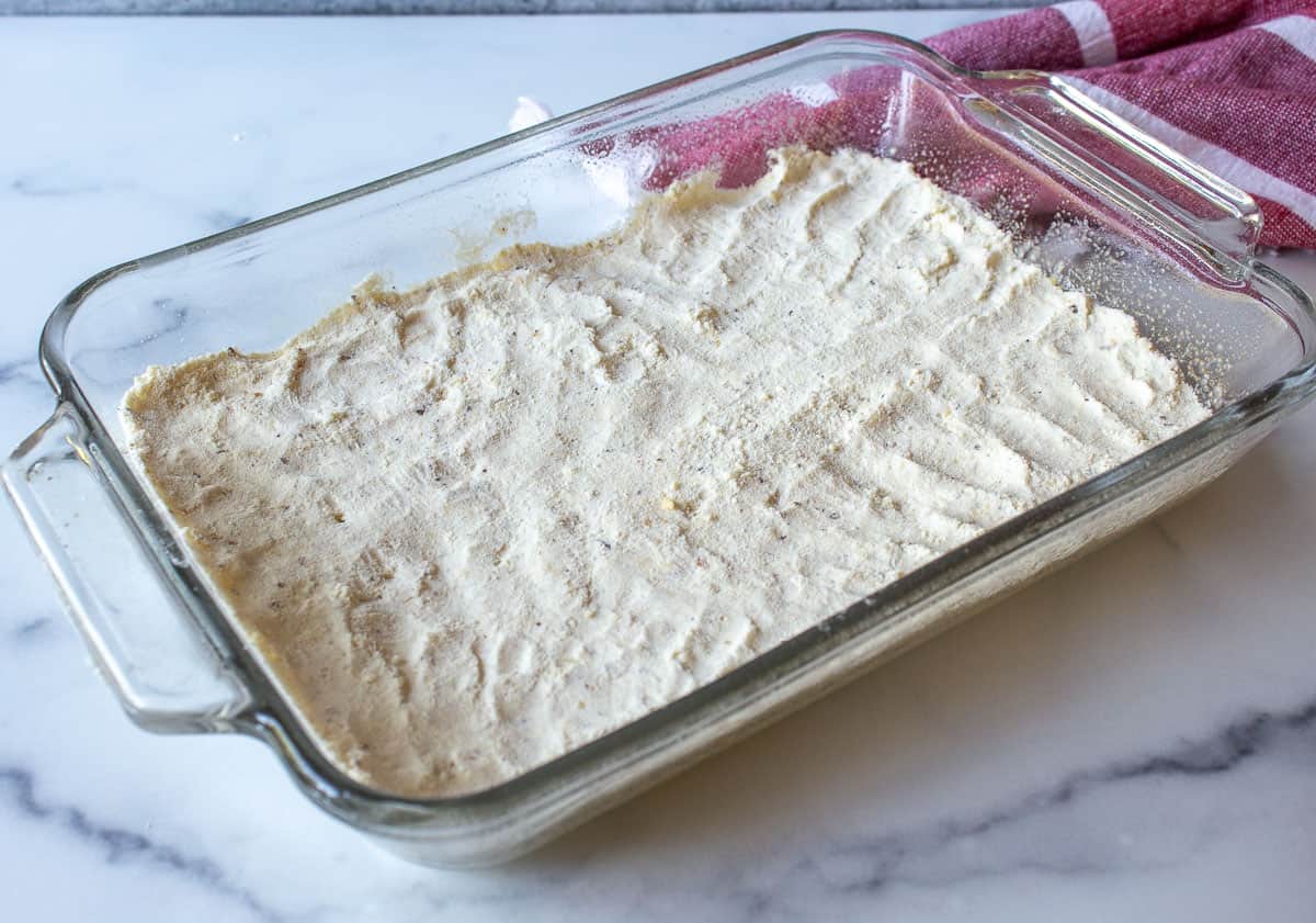 Shortbread crust mixture in a baking dish.