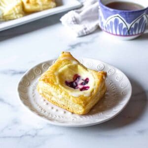 A danish filled with cream cheese and berries on a white plate.