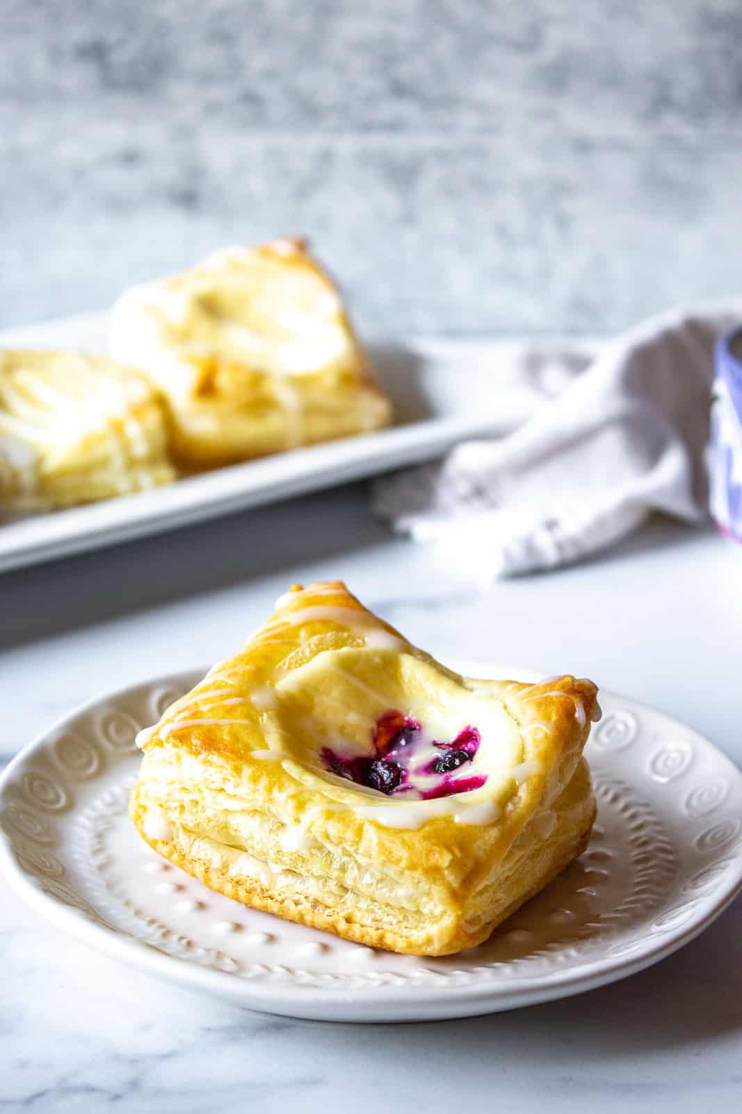Cheese and berry danish on a white plate.