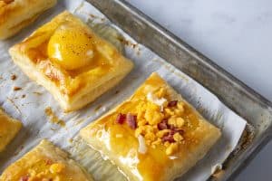 Puff pastry with raw egg topped with cheese and bacon.