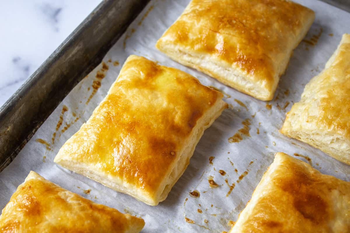 Puff pastry squares on a baking sheet.