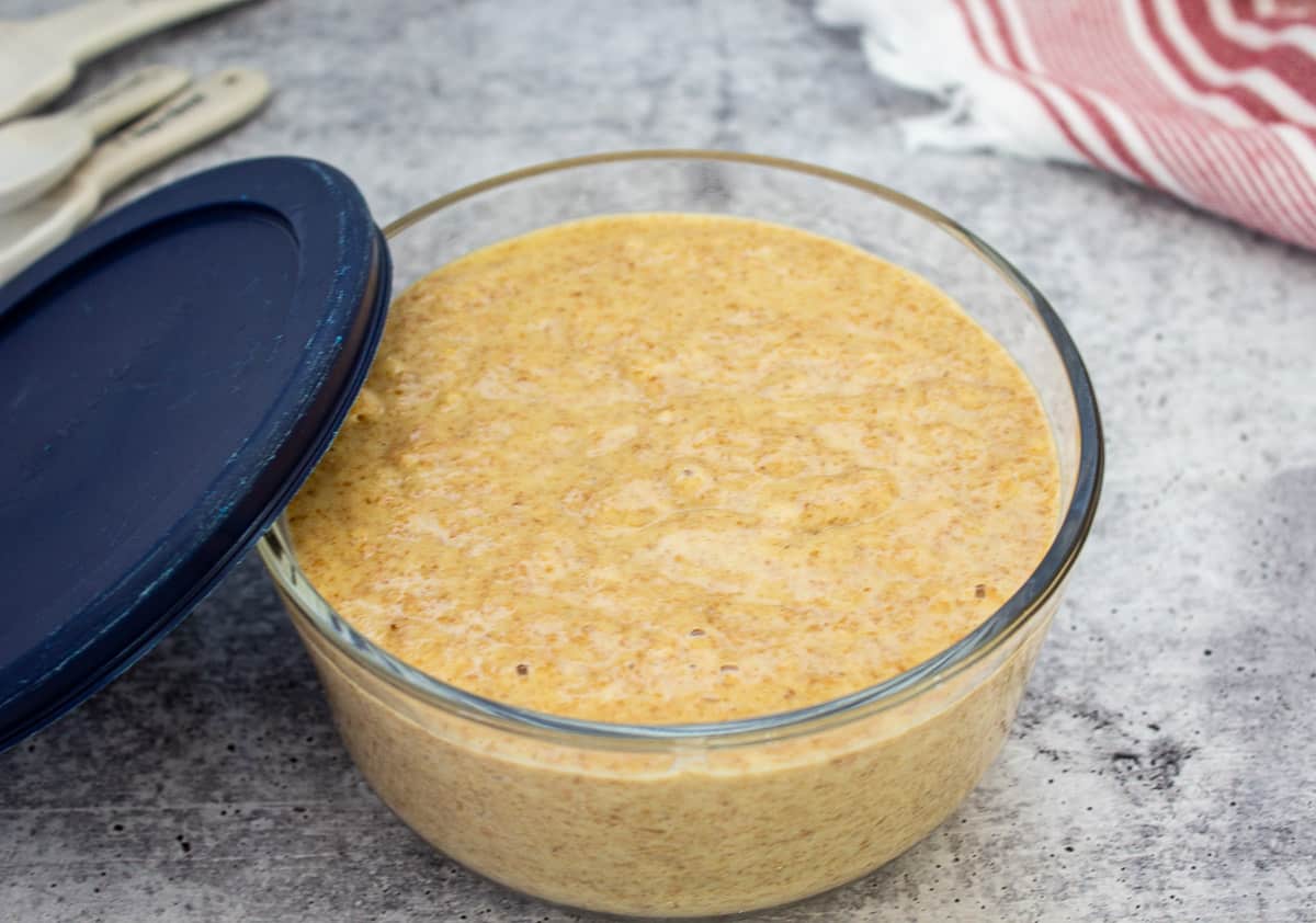 A glass bowl filled with bran muffin batter.