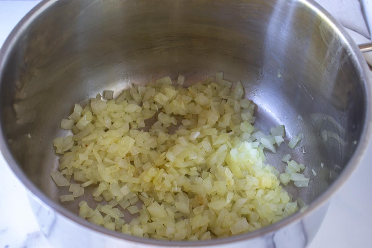 Onions sautéing in a soup pot.