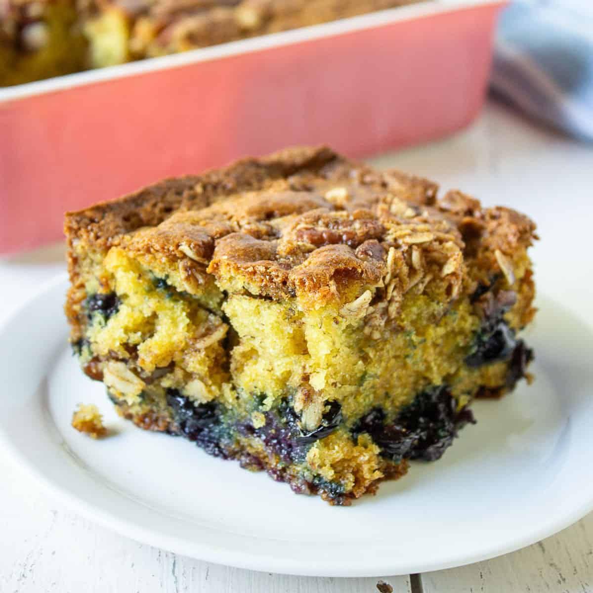 A slice of yellow coffee cake filled with blueberries.