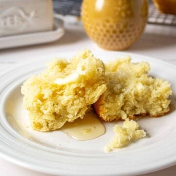 A biscuit cut in half topped with butter and honey.