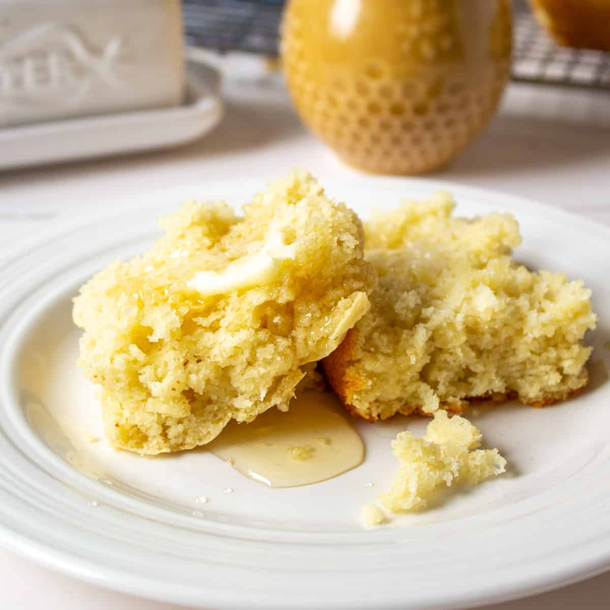 Buttermilk pan biscuit cut in half topped with butter and honey.