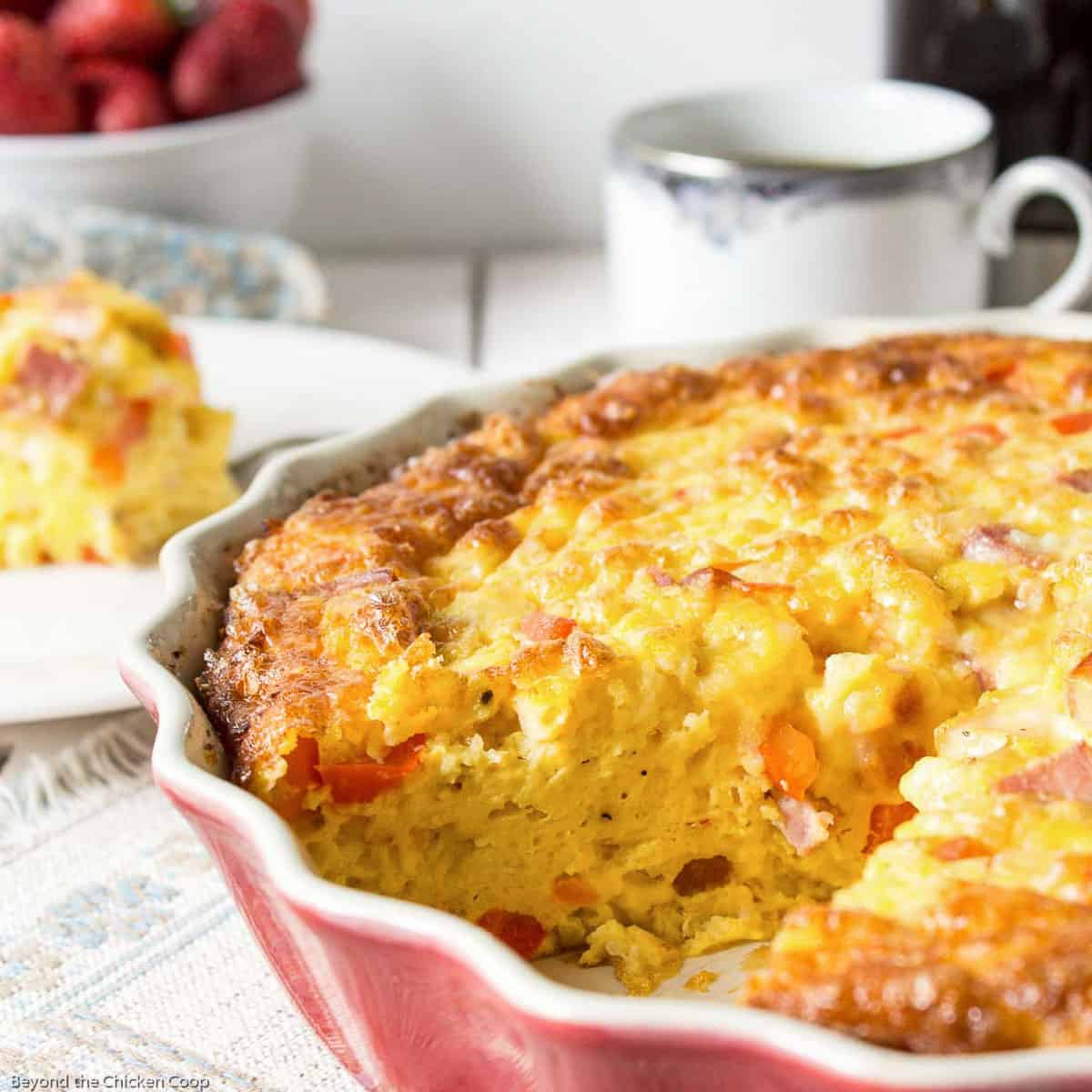 An egg casserole in a pink colored pie dish.