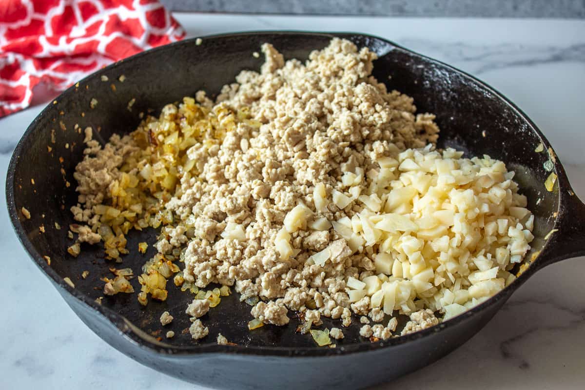 A mixture of cooked ground chicken and onions with chopped water chestnuts.