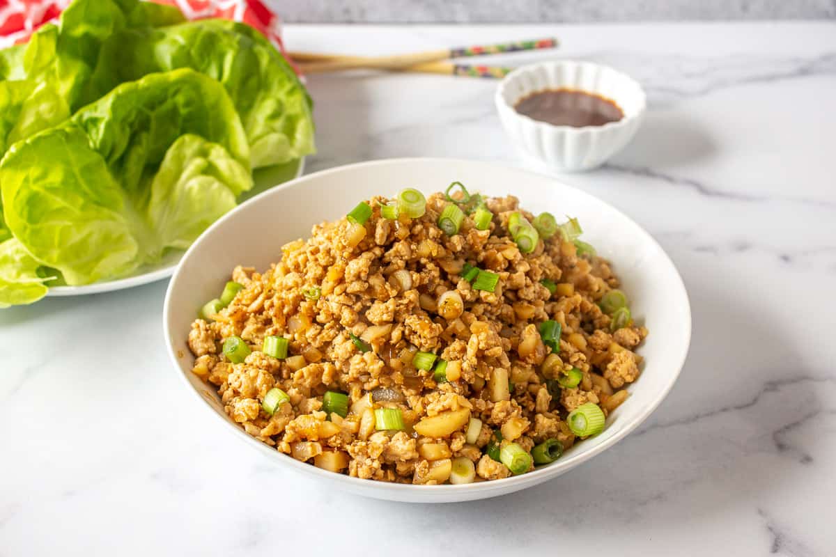 A bowlful of of chicken mixture topped with fresh parsley