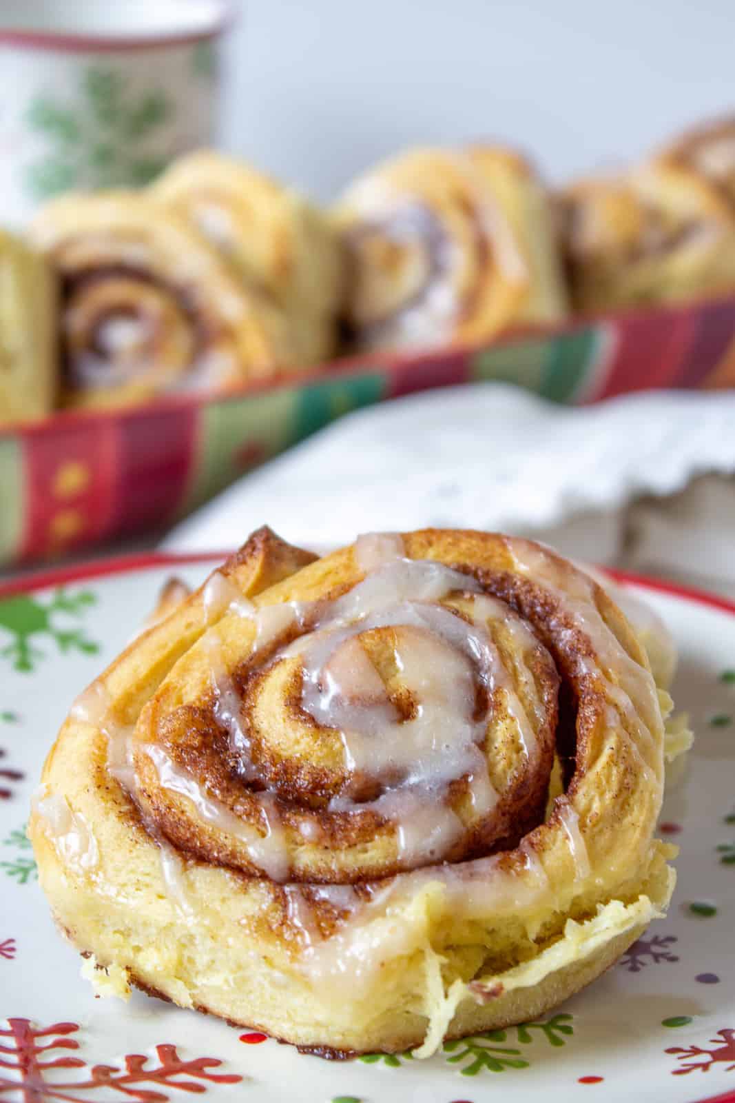 A cinnamon roll topped with a drizzled glaze.