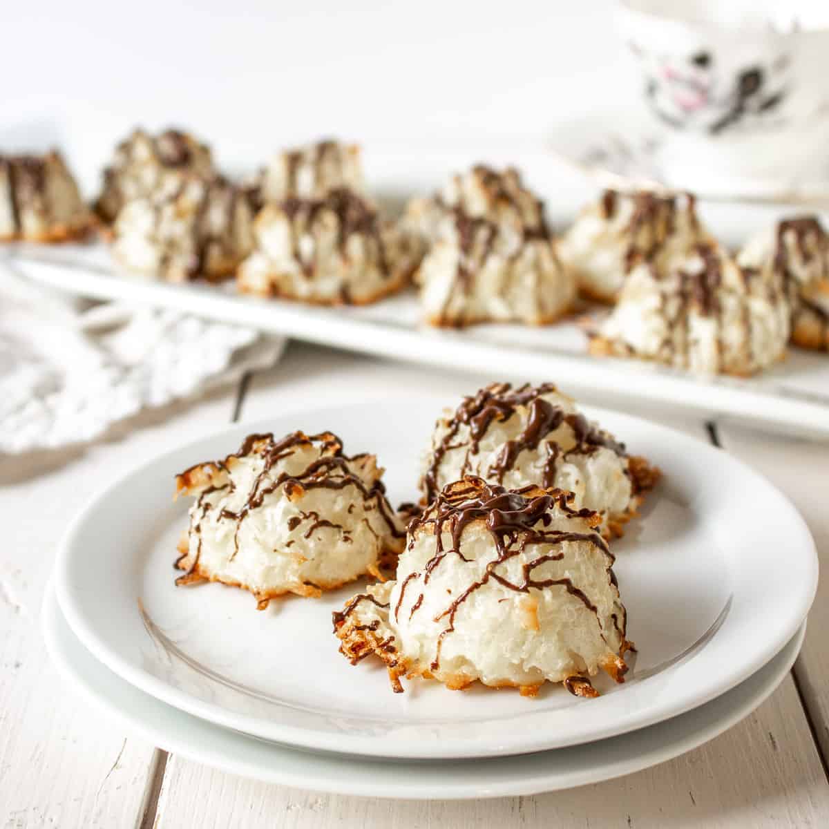 Three coconut macaroon cookies with a chocolate drizzle across the top.