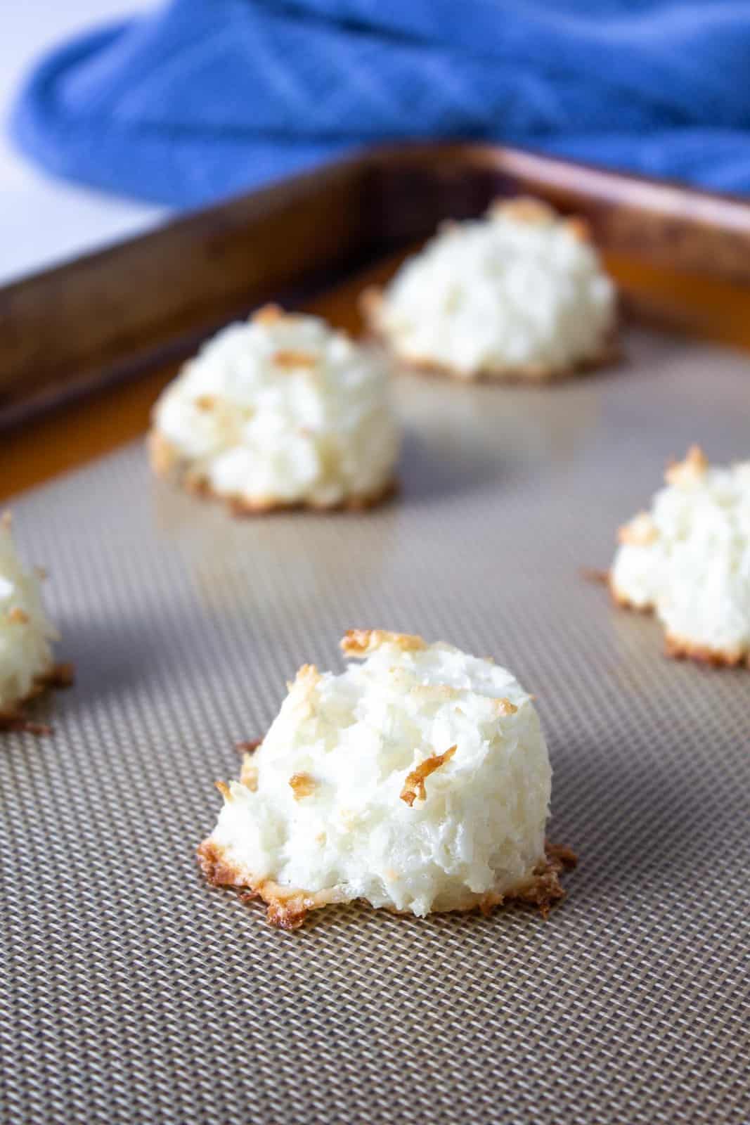 Baked coconut cookies on a baking sheet.