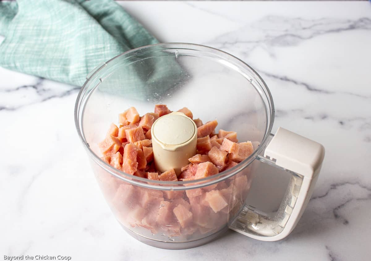 Chopped ham in a food processor bowl.