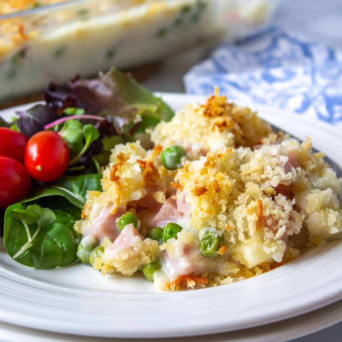 Ham, rice and pea casserole on a plate with a salad.