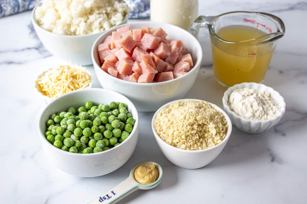 Small bowls filled with frozen peas, ham, rice, bread crumbs and seasonings. 