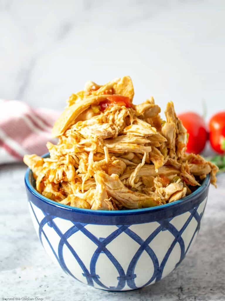 A blue and white patterned bowl filled with shredded chicken.