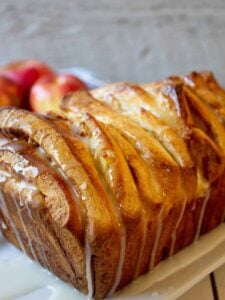 A loaf of pull apart bread with a white glaze drizzled across the top.