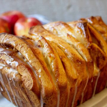 A loaf of pull apart bread with a white glaze drizzled across the top.