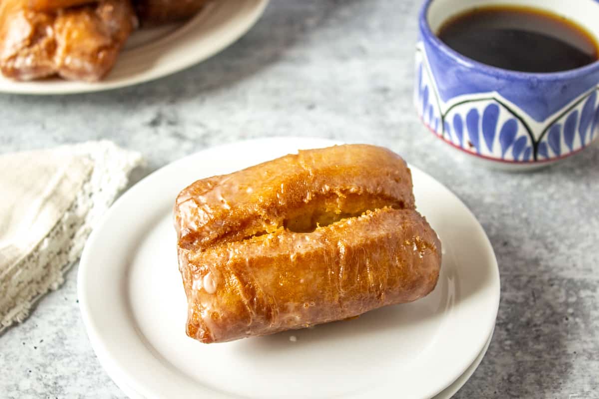 An old fashioned donut on a white plate.