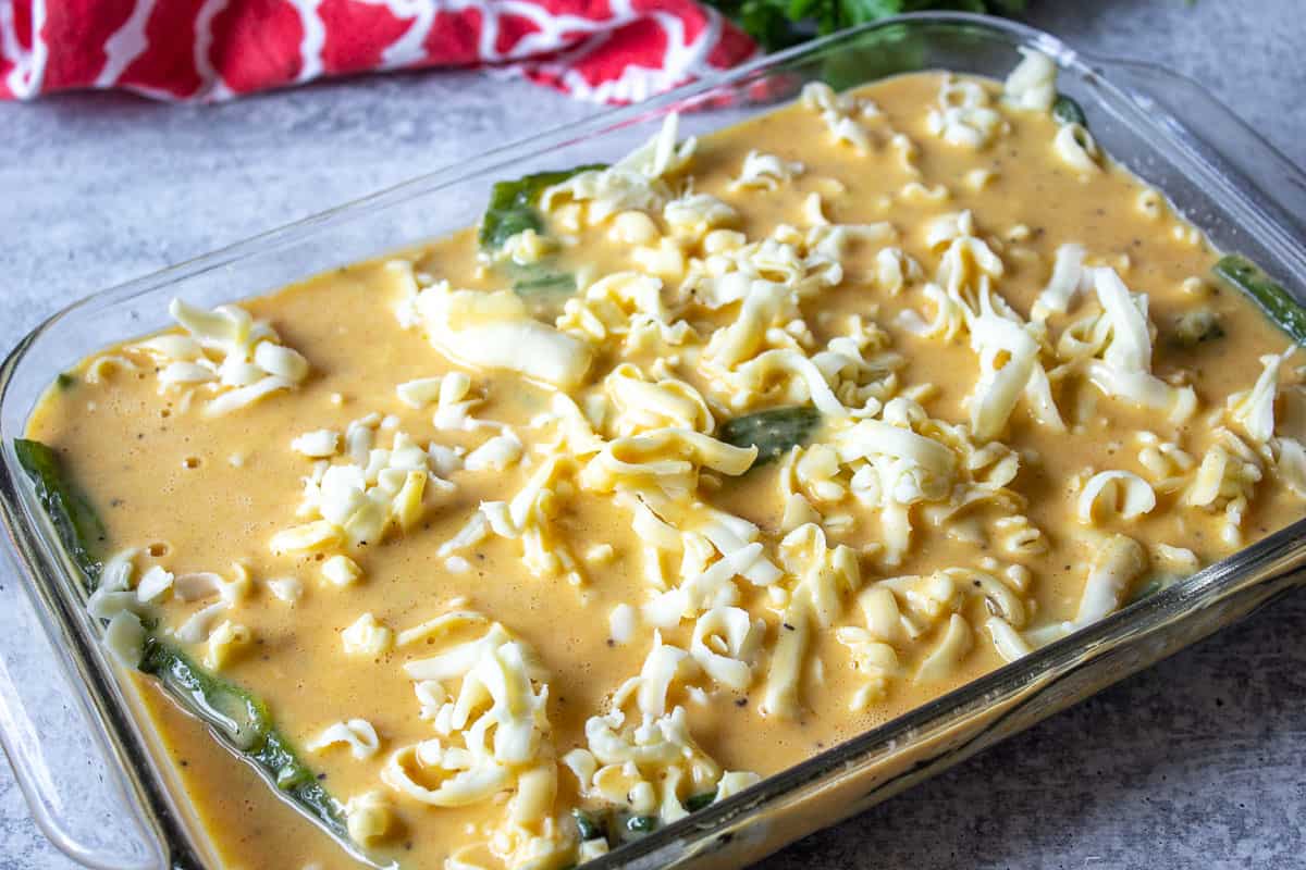 An unbaked chili relleno casserole in a glass baking dish.