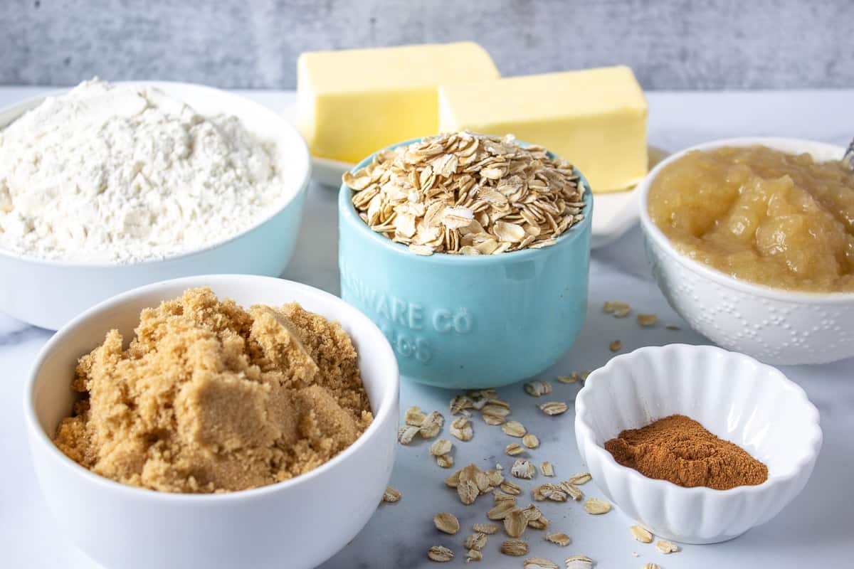 Small bowls filled with brown sugar, oatmeal, cinnamon and butter.