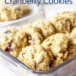 A glass storage container stacked with oatmeal cookies.