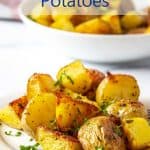 Cubed potatoes on a plate sprinkled with fresh parsley.