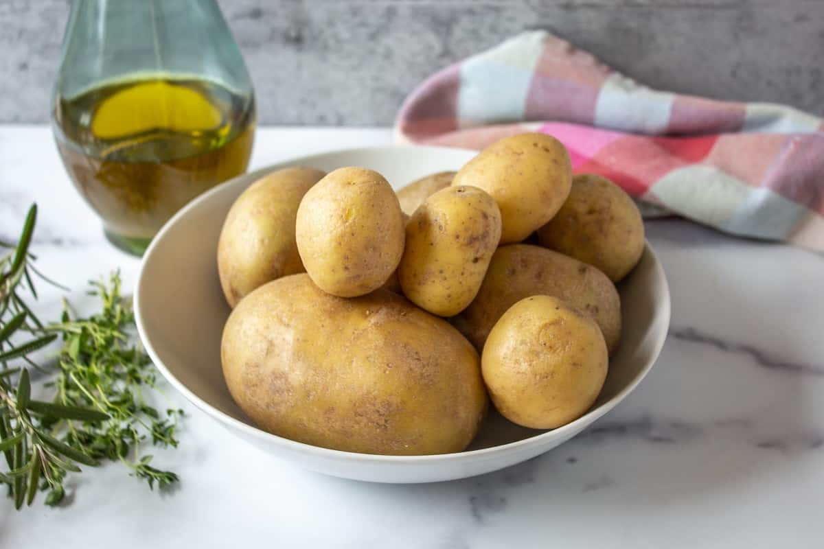 A bowl of different sized yukon potatoes. 