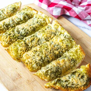 Slices of french bread topped with pesto and cheese.