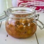 A glass crock filled with a chunky rhubarb sauce.