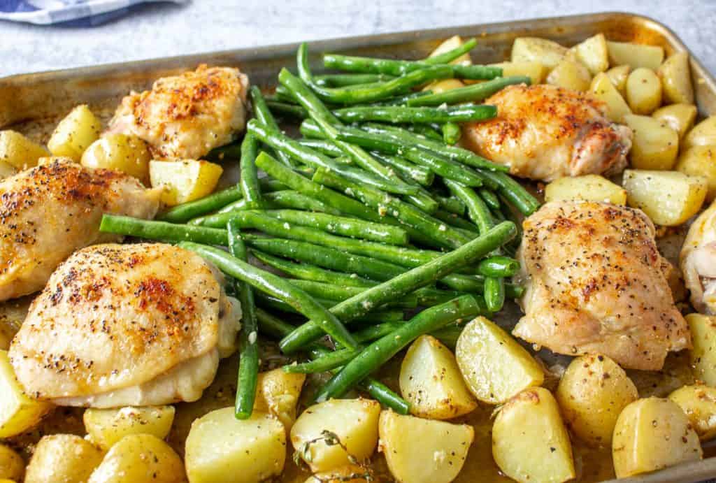 A sheet pan dinner with chicken, potatoes and green beans.