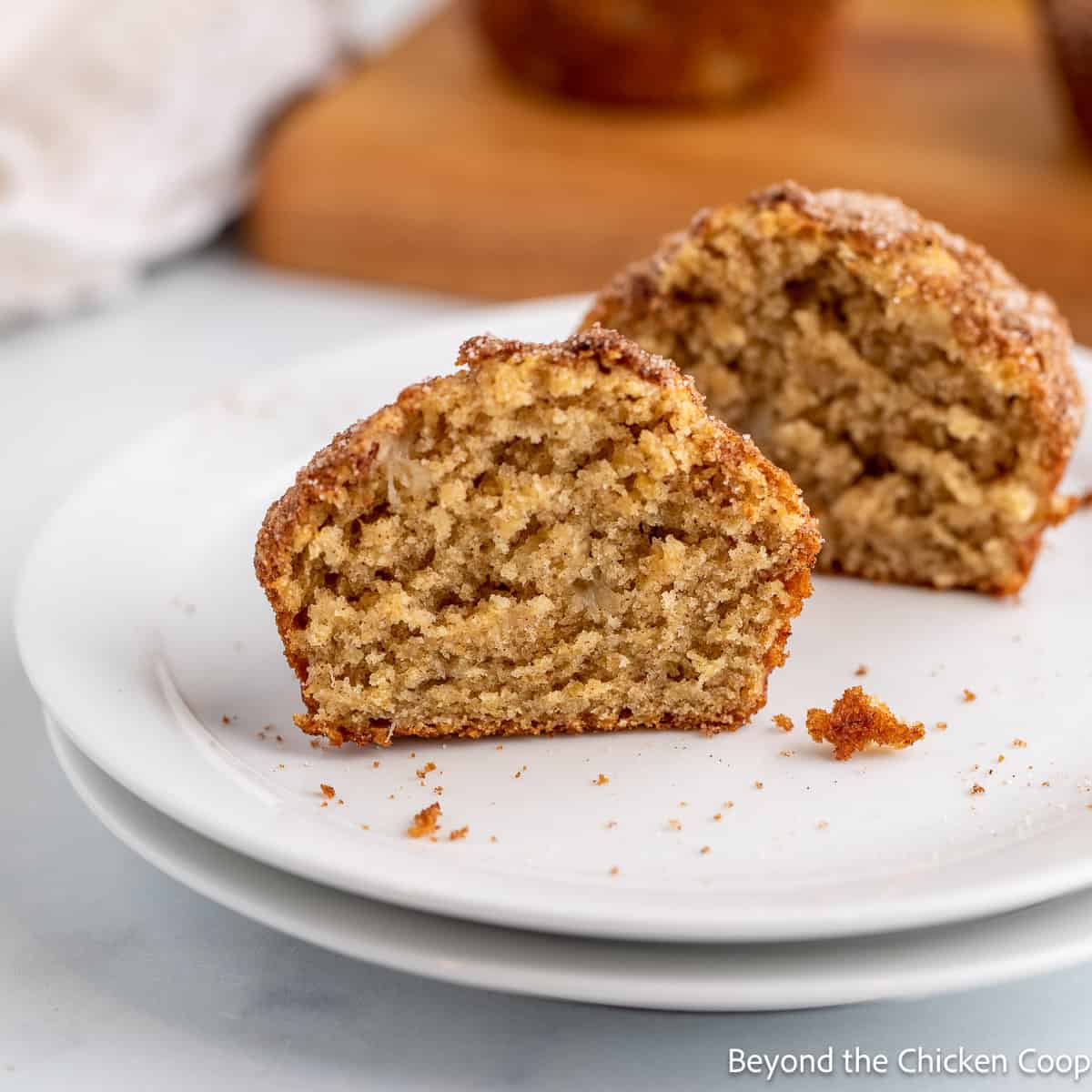 A banana muffin cut in half on a white plate. 