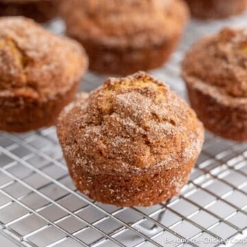 Cinnamon muffins on a baking rack.