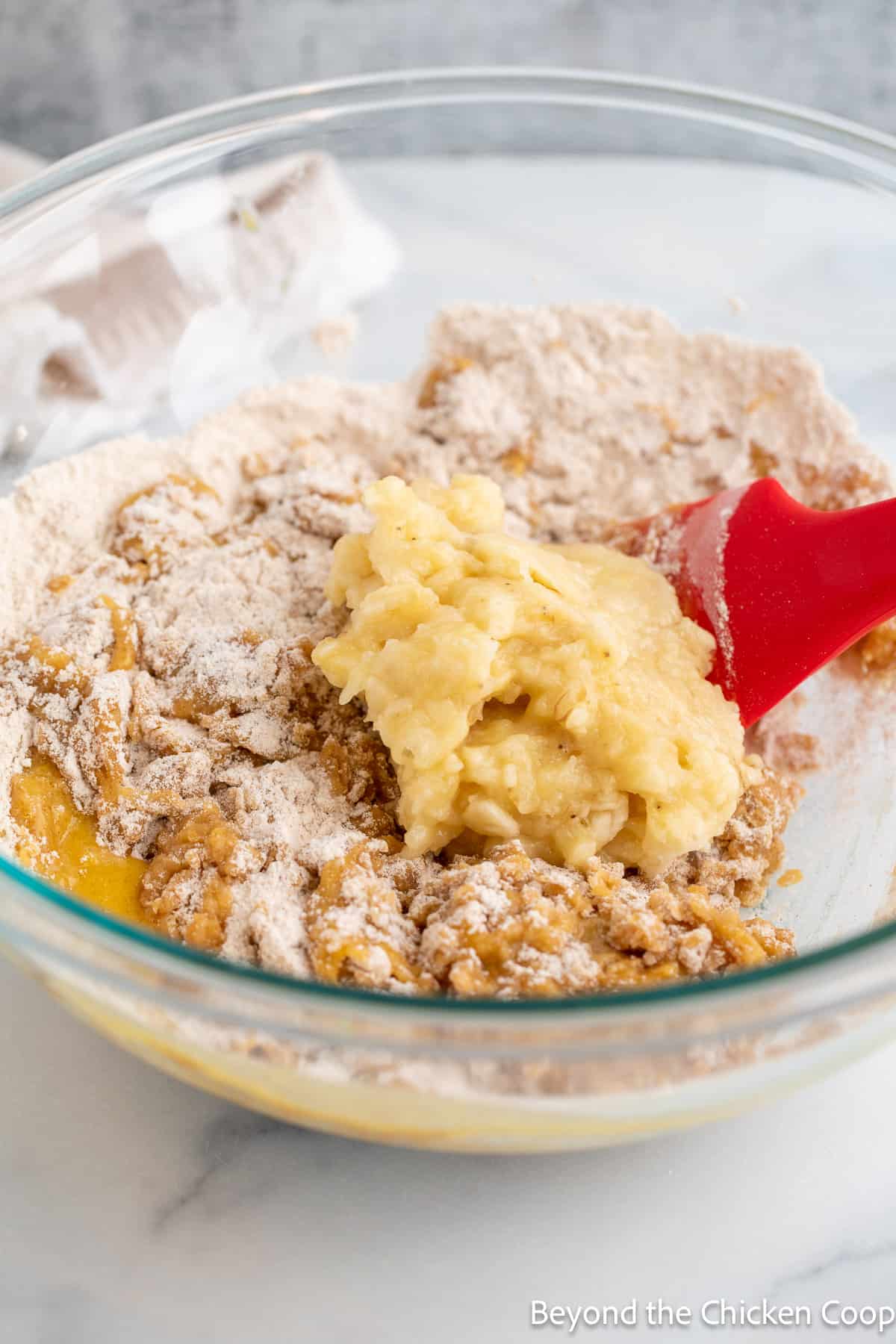 Mixing muffin batter with a red spatula. 