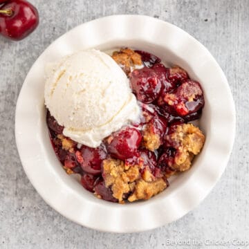 A cherry dessert topped with a scoop of ice cream.