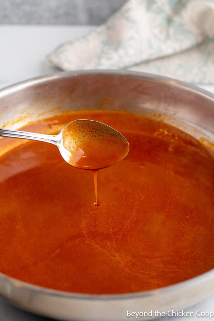 Testing the consistency of a sauce with a spoon. 