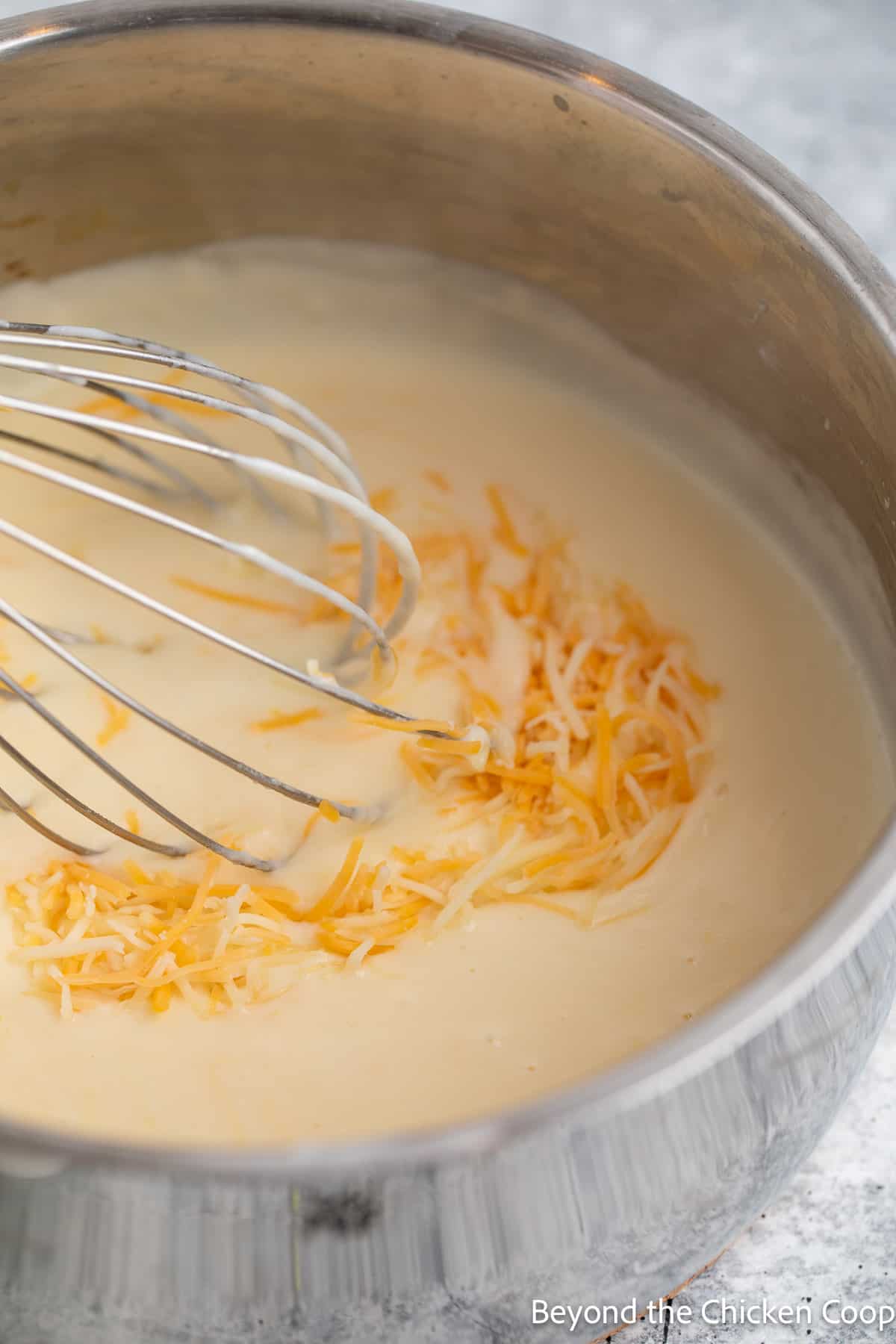 Whisking cheese into a sauce.