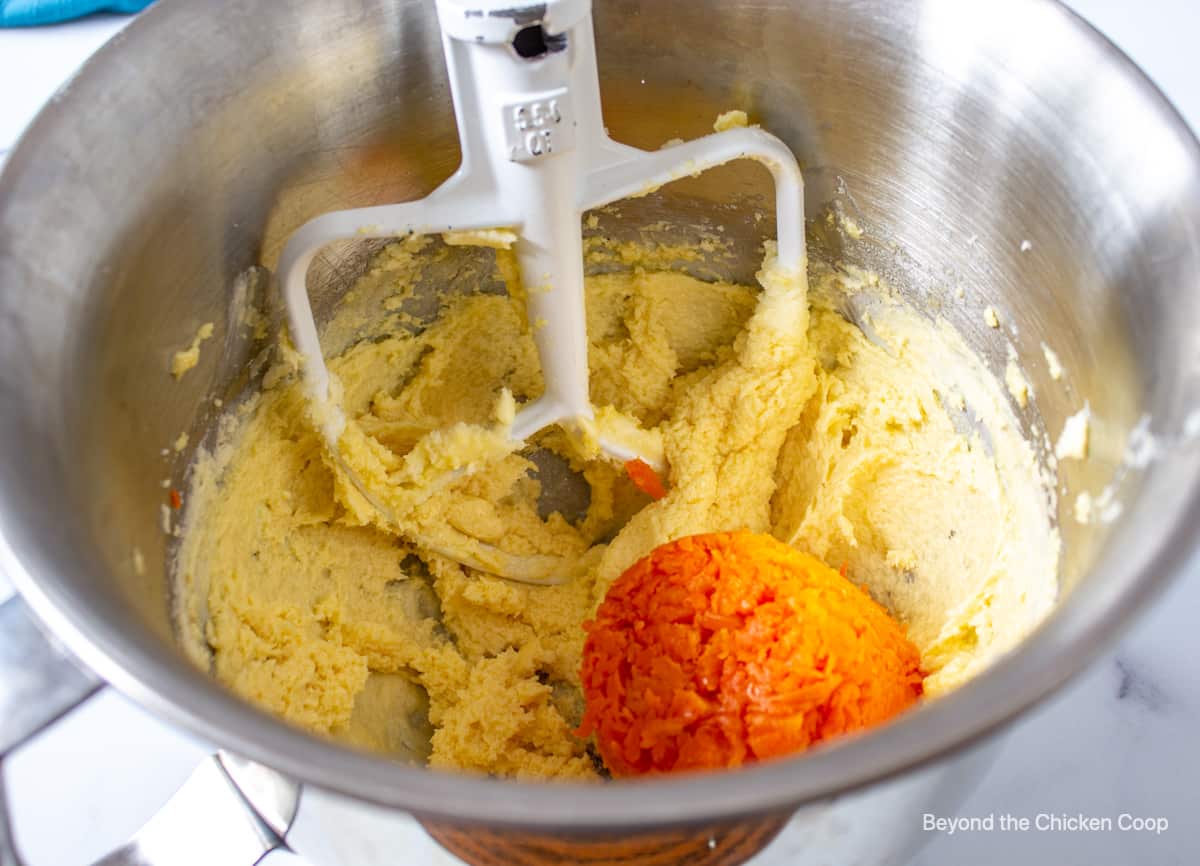 A mixing bowl with cookie dough and mashed carrots.