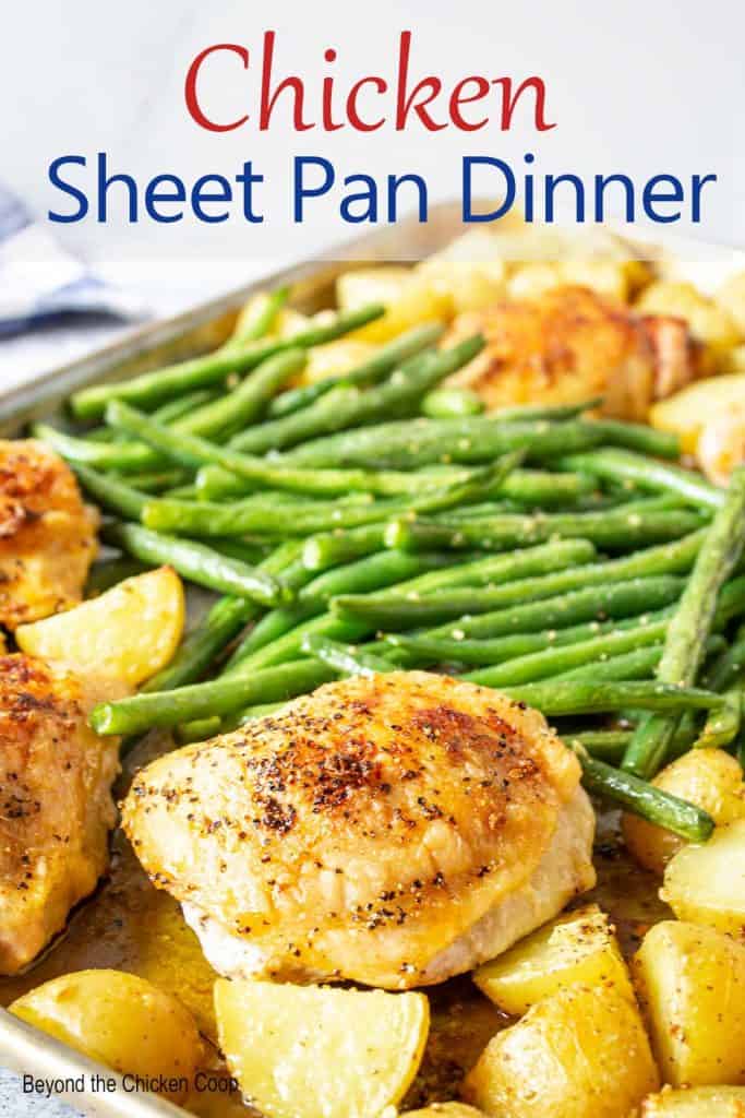 A sheet pan filled with potatoes, green beans and chicken.