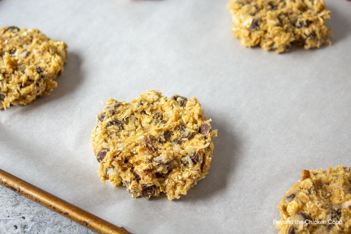 Cookie dough flattened into discs on a baking sheet.