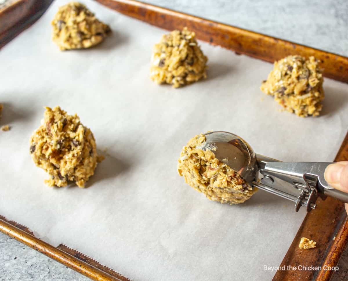 Forming cowboy cookies on a baking sheet.